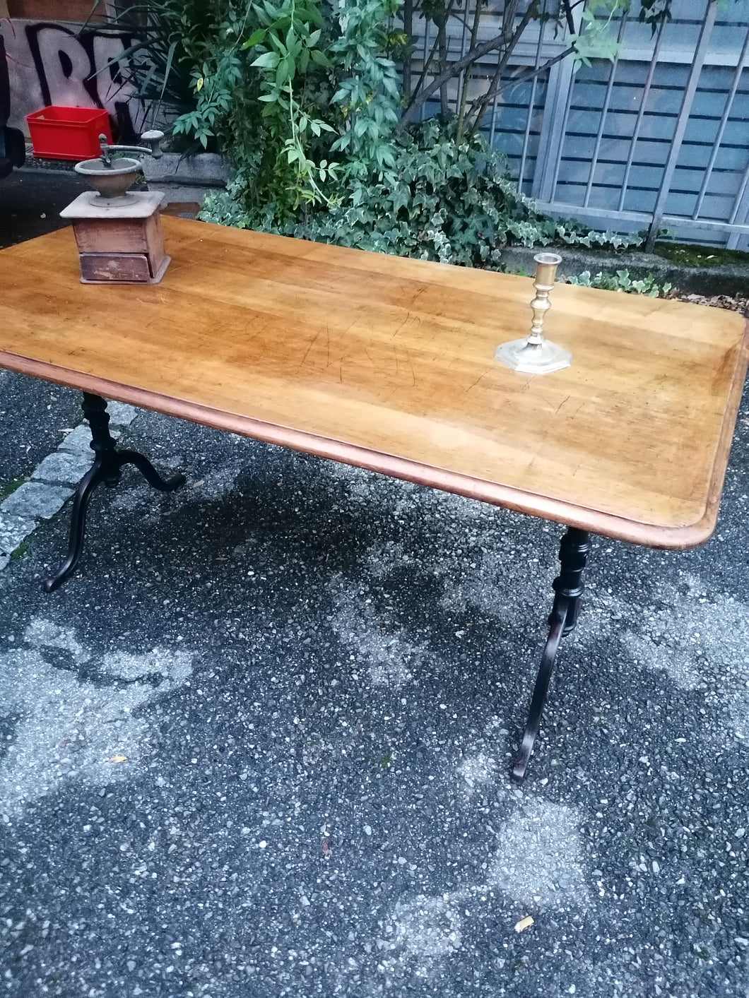 Table de bistrot ancienne, plateau en noyer massif. Pieds en fonte. Bords arrondis.