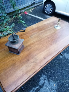 Table de bistrot ancienne, plateau en noyer massif. Pieds en fonte. Bords arrondis.