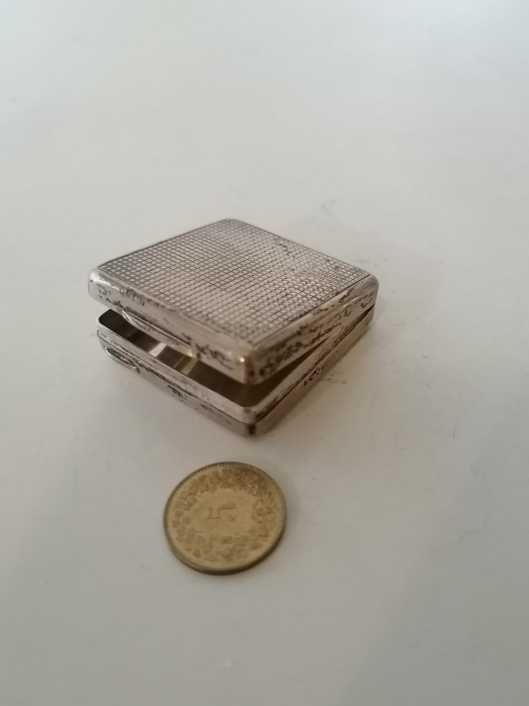 Petite boîte à pilule carré en argent.