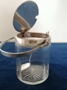 Sucrier cristal et argent à système, c'est la poignée qui actionne le couvercle quand on le rabat.