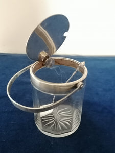 Sucrier cristal et argent à système, c'est la poignée qui actionne le couvercle quand on le rabat.