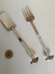 Object mystérieux, probablement une paire de service à sardine .. ça y ressemble .. acier gravé à l'acide et manche nacre