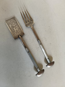Object mystérieux, probablement une paire de service à sardine .. ça y ressemble .. acier gravé à l'acide et manche nacre