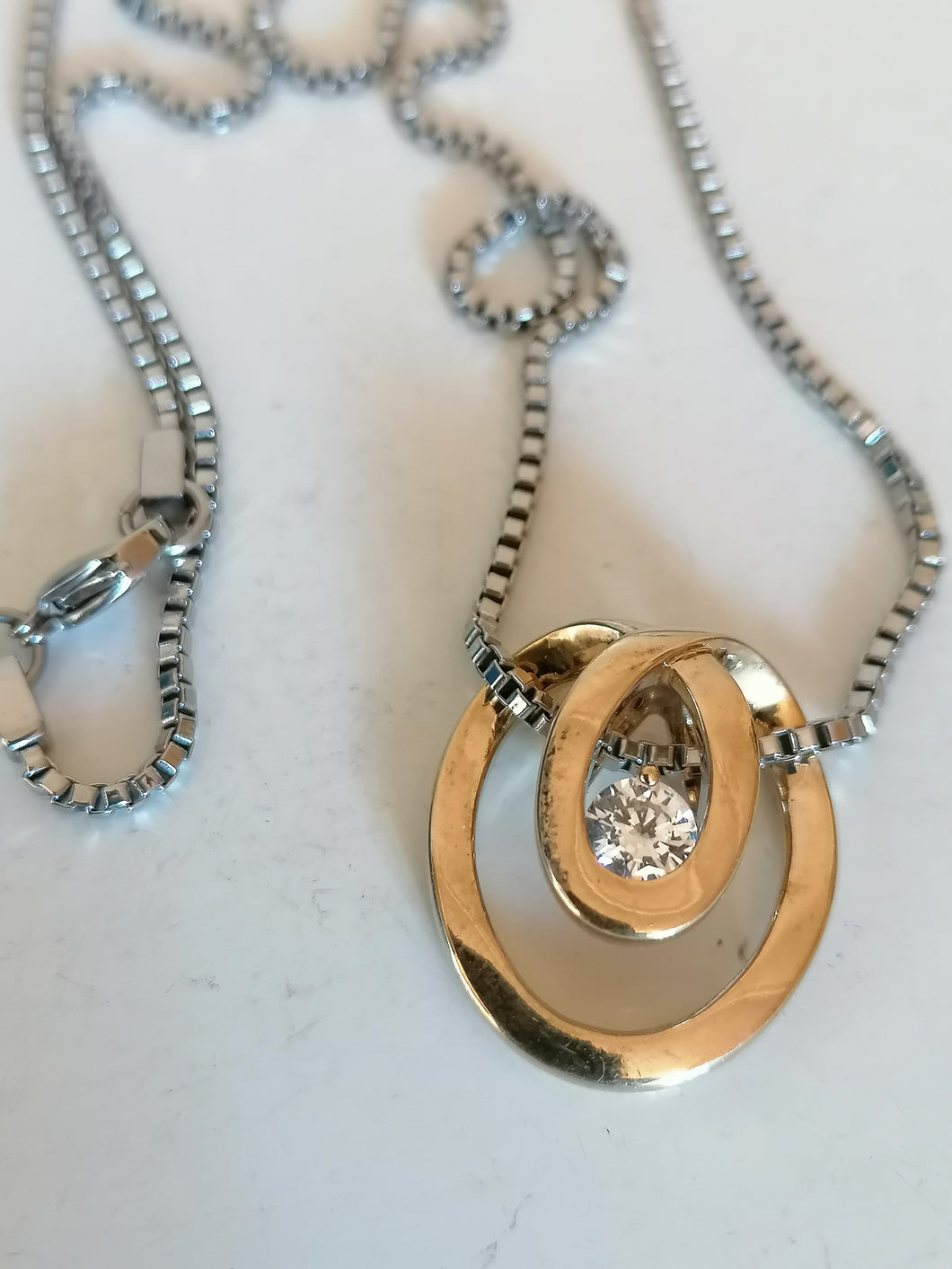 Chaîne avec pendentif doré et cristal taillé.