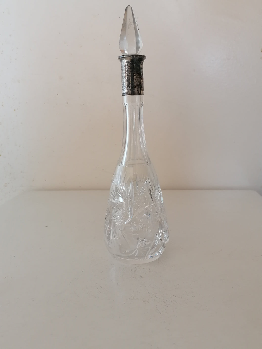 Carafe en cristal taillé et col en argent. 