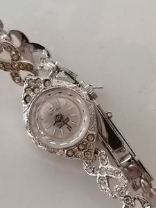 Initial montre bracelet dame rhodié et strass. Mouvement mécanique