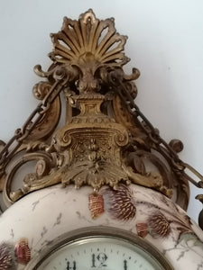 Pendule boulangère en faïence de forme circulaire à décor polychrome de chardons. Monture en bronze doré
