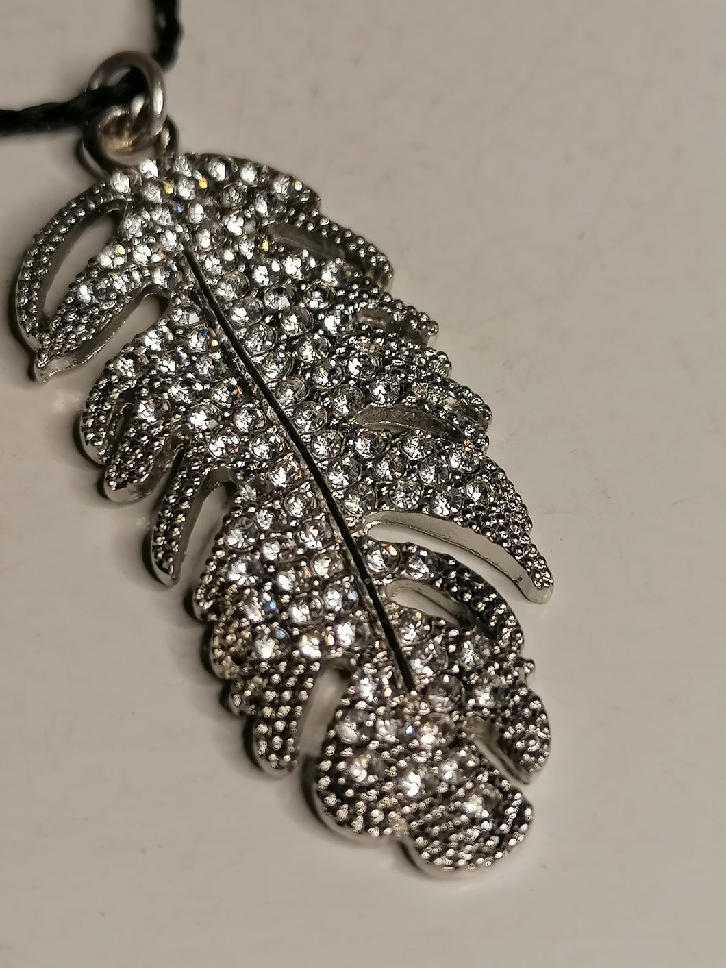 Pendentif plume et strass. 