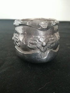 Petite pot en métal argenté repoussé.