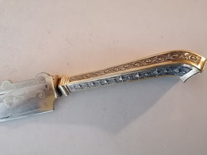 Coûteau à gâteau manche en argent massif doré. Lame avec un peu d'usure. 